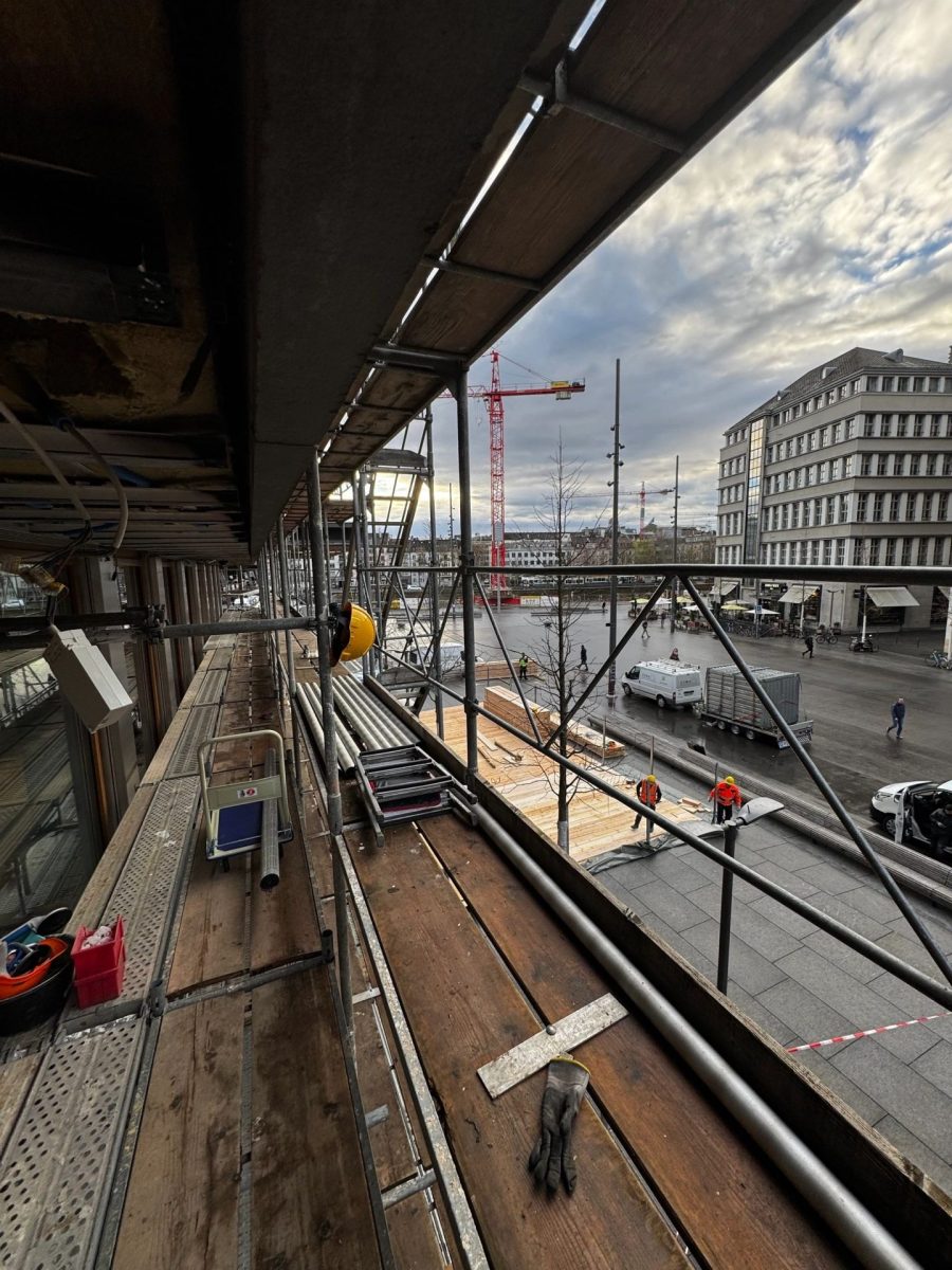 Gerüstlaufsteg mit Material; Blick auf Baustelle und Kräne