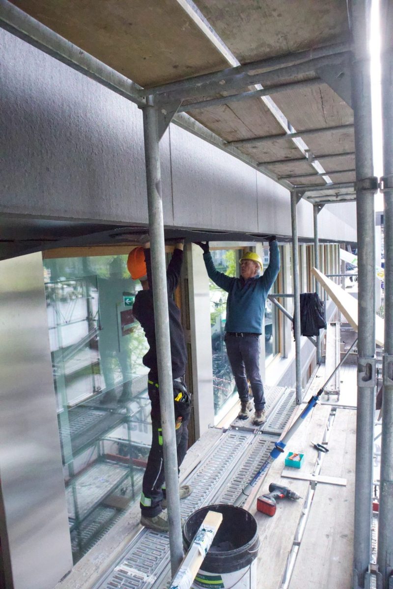 Montage an Fensterfront auf Gerüst – zwei Handwerker