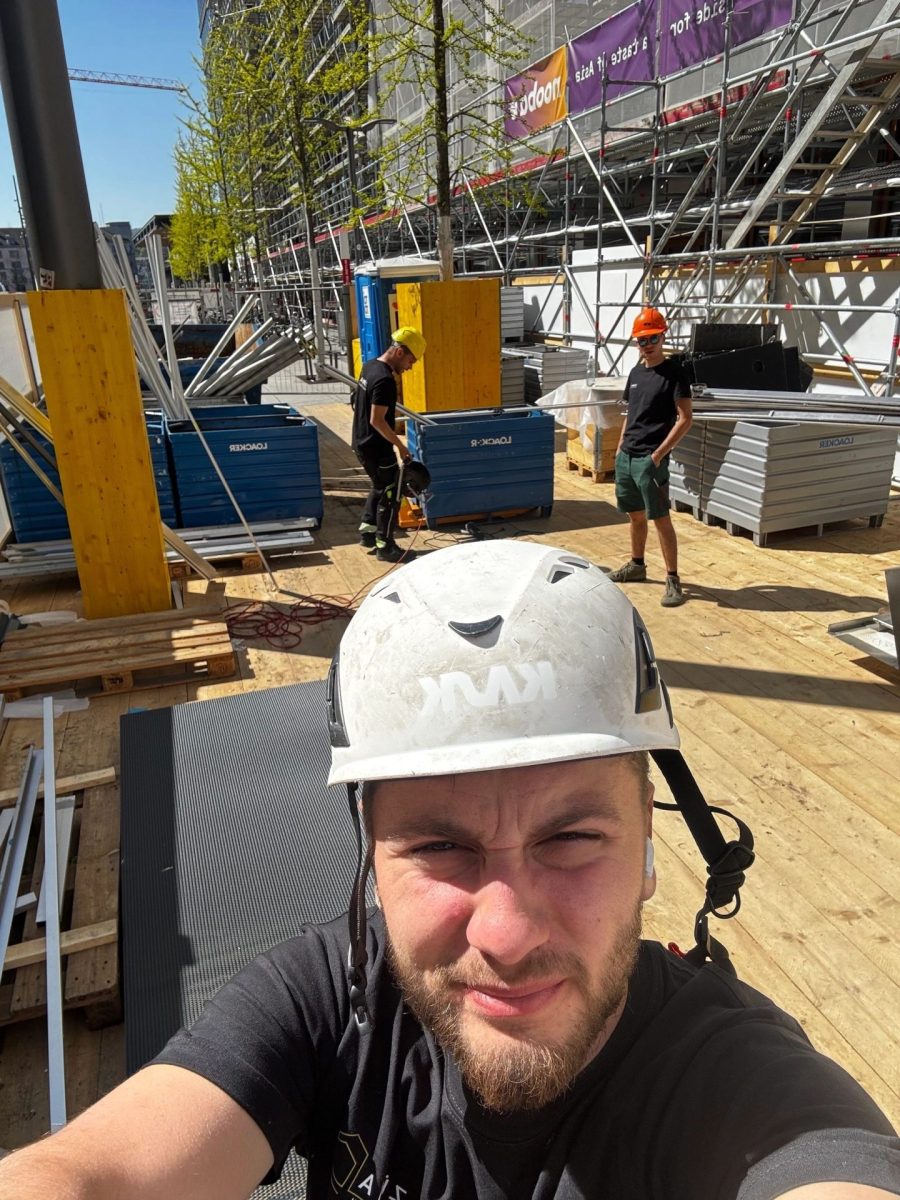 Monteure auf Baustelle; Selfie mit Schutzhelm auf Gerüst
